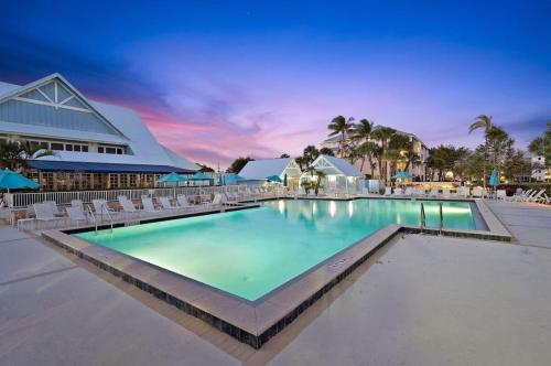 a large swimming pool with chairs and a building at Beachside Modern Wellness at Jupiter Bay Resort in Jupiter