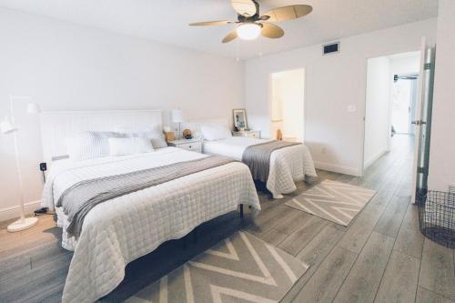 a bedroom with two beds and a ceiling fan at Beachside Modern Wellness at Jupiter Bay Resort in Jupiter