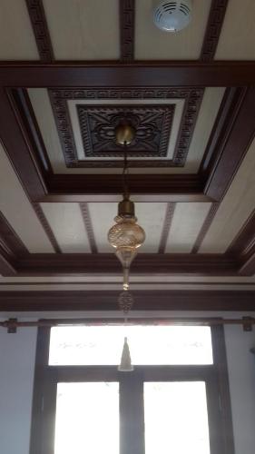 a coffered ceiling with a chandelier in front of a window at Hotel Mary's House in Selcuk