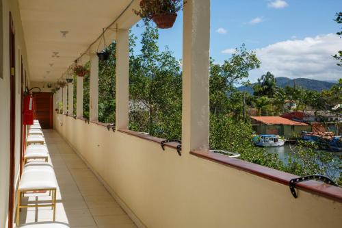a balcony with chairs and a view of the water at Loft Barra dos pescadores in Ubatuba