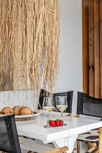 a white table with two glasses of wine and vegetables at Captain Zeppos in Pollonia