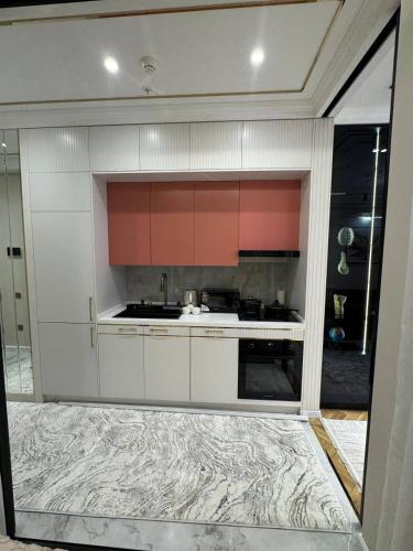 a kitchen with orange and white cabinets and a sink at Nest one in Tashkent