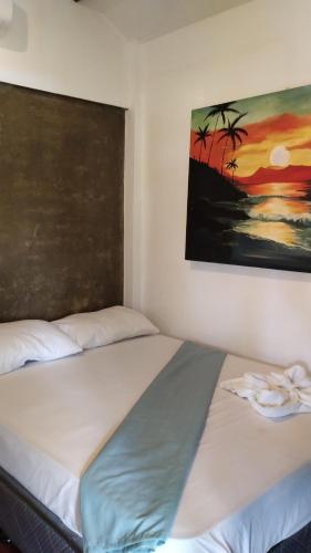 two beds in a room with a painting on the wall at Lutaw Farm Pool and Villas in General Luna