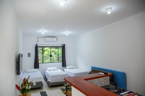 a living room with two beds and a window at Loft Barra dos pescadores in Ubatuba