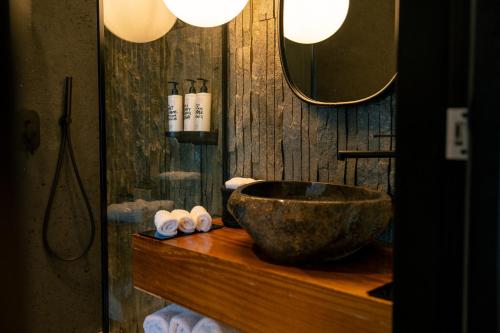 a bathroom with a stone bowl on a wooden counter at Captain Zeppos in Pollonia