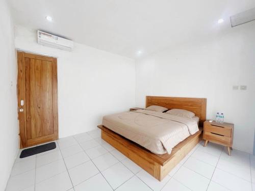 a bedroom with a bed and a wooden bed frame at Sonteng homestay in Sengkol