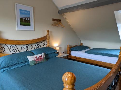 a bedroom with two beds with blue sheets at Llangollen Hostel - Book the Whole Room - Self Catering in Llangollen