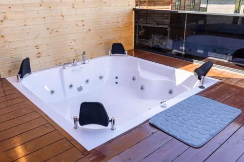 eine große weiße Badewanne mit zwei Stühlen darin in der Unterkunft Via Bungalows Batumi in Batumi