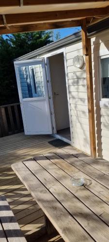 a porch with a white door and a wooden deck at provence au pied du Luberon emplacement 325 domaine des iscles in La Roque-dʼAnthéron