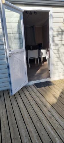 an open door on a house with a table and chairs at provence au pied du Luberon emplacement 325 domaine des iscles in La Roque-dʼAnthéron