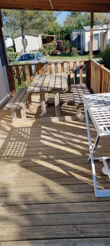 a wooden bench sitting on top of a deck at provence au pied du Luberon emplacement 325 domaine des iscles in La Roque-dʼAnthéron