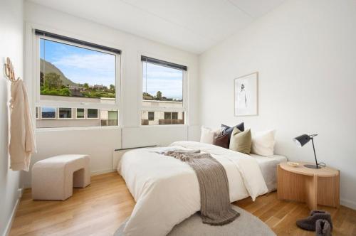 Un dormitorio blanco con dos camas y una ventana. en Large 3 bedroom apartment in the center with parking, en Vossevangen