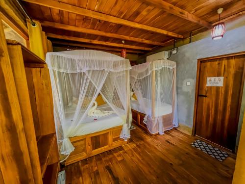 a room with two beds with mosquito nets in it at Habarana Tree House Ambasewana Resort in Habarana