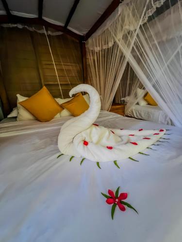 a white swan laying on a bed at Habarana Tree House Ambasewana Resort in Habarana