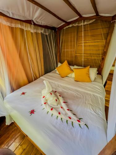 a bed in a tent with flowers on it at Habarana Tree House Ambasewana Resort in Habarana