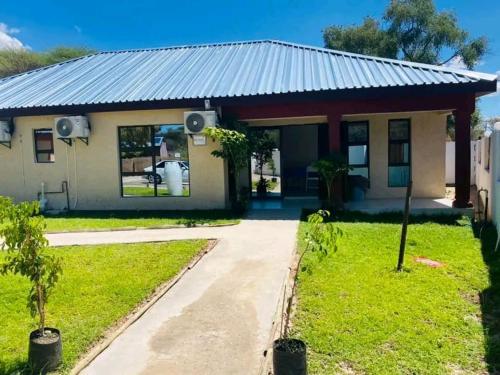 a house with a blue tin roof at Atoma Lodge in Shakawe
