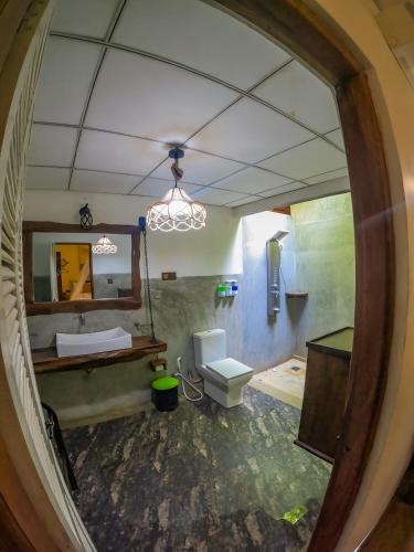 a bathroom with a toilet and a mirror at Habarana Tree House Ambasewana Resort in Habarana