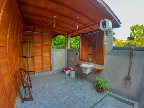 an outdoor bathroom with a toilet and a sink at Habarana Tree House Ambasewana Resort in Habarana