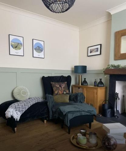 a living room with a bed and a chair at Old Store Cottage, Up Holland in Upholland