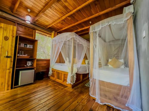 a bedroom with two beds in a wooden cabin at Habarana Tree House Ambasewana Resort in Habarana