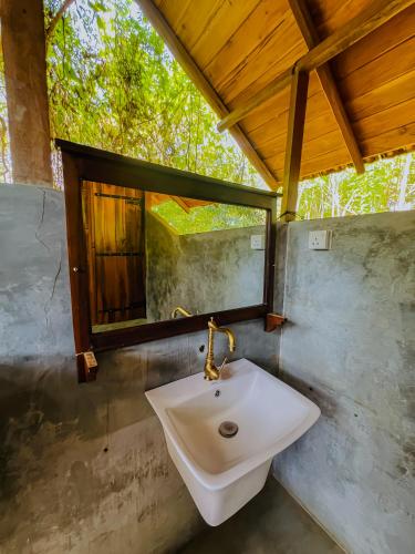 a bathroom with a sink and a mirror at Habarana Tree House Ambasewana Resort in Habarana