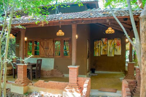 a small house with a table in front of it at Habarana Tree House Ambasewana Resort in Habarana