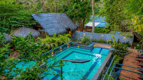 a swimming pool in the middle of a garden at Habarana Tree House Ambasewana Resort in Habarana