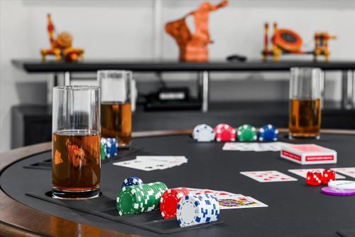 a table with poker chips and two glasses of beer at Spacious 6BR Getaway Game Room Firepit NYC in Elmsford