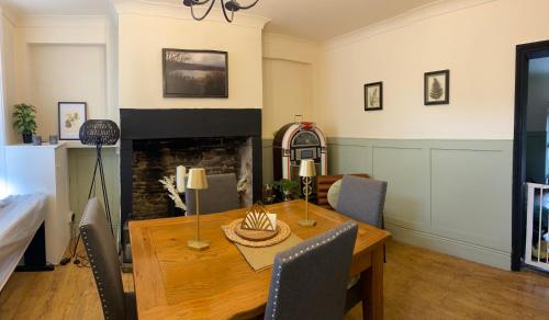 a dining room with a table and a fireplace at Old Store Cottage, Up Holland in Upholland