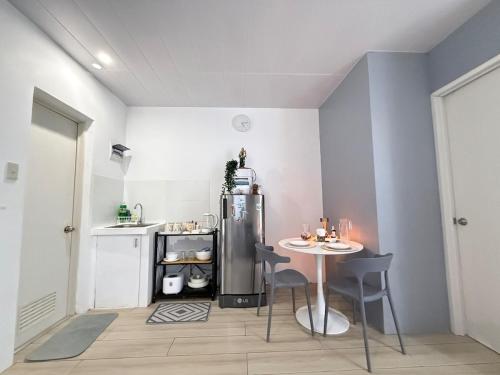 a small kitchen with a table and a refrigerator at H&K Partner Guest House 