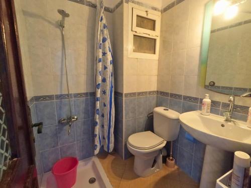 Un baño con inodoro, lavabo y ducha. en Martil Apartment Near Beachfront, en Martil