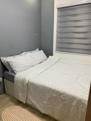 a bed with white sheets and a window in a bedroom at H&K Partner Guest House 