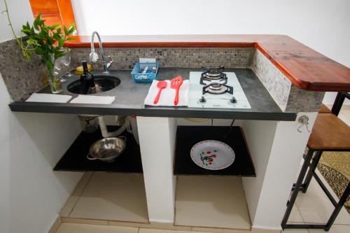 a kitchen counter with a sink and a stove at Loft Barra dos pescadores in Ubatuba