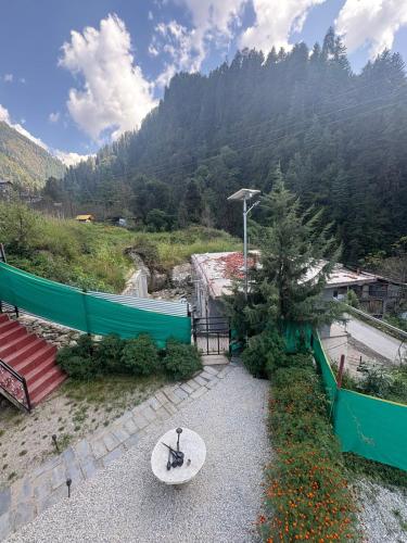 a patio with a table and a view of a mountain at The Pahadi Soul Stay and Café in Jibhi
