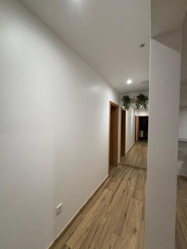 an empty hallway with white walls and wood floors at Casa de Arcas in Terras de Bouro
