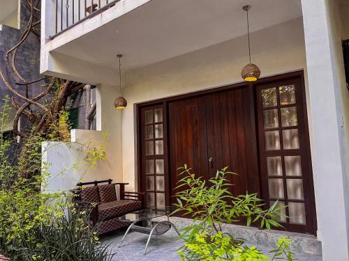 a wooden front door of a house with a bench at Sundaras Sigiriya Jungles Caves Resort in Dambulla
