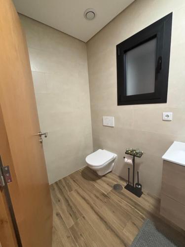 a bathroom with a toilet and a tv on the wall at Casa de Arcas in Terras de Bouro