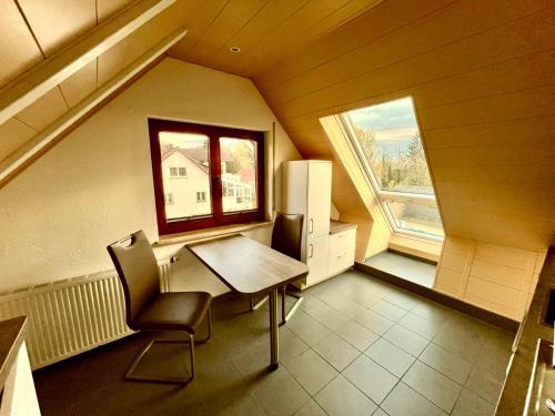 a kitchen with a table and chairs and a window at Ferienwohnung Schwalbennest in Radolfzell am Bodensee