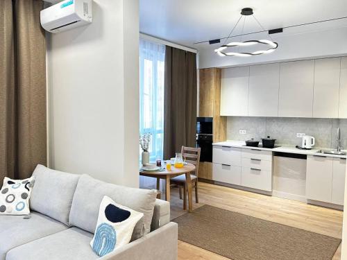 ein Wohnzimmer und eine Küche mit einer Couch und einem Tisch in der Unterkunft ЦЕНТР ГОРОДА & PERFECT APARTMENT & CENTER OF THE CiTY in Almaty