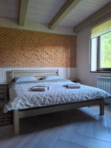 a large bed in a room with a brick wall at Lucy in Yaremche