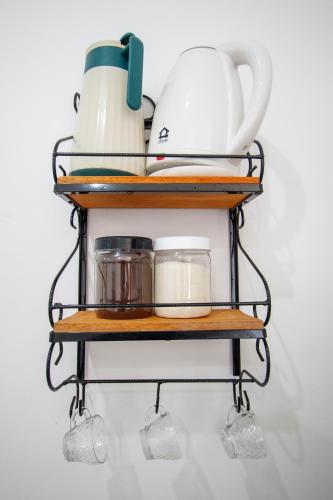 a shelf with a tea pot and other items on it at Loft Barra dos pescadores in Ubatuba