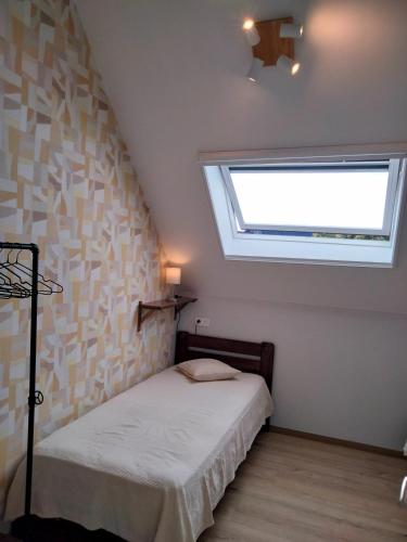 a small bedroom with a bed and a window at Les Campanes - Gite 8 personnes avec piscine intérieure et sauna 