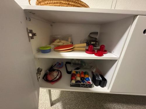 a white cupboard with some toys in it at Hyggeligt værelse i hjertet af Lunderskov in Lunderskov