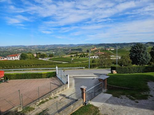 an empty parking lot with a fence and a field at A casa di Thelma in Barolo