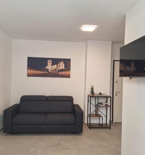 a living room with a couch and a television at Il Nido a Due Passi da Assisi in Bastia Umbra