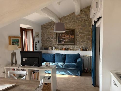 a living room with a blue couch and a table at Castle Apartment with Lake View in Passignano sul Trasimeno