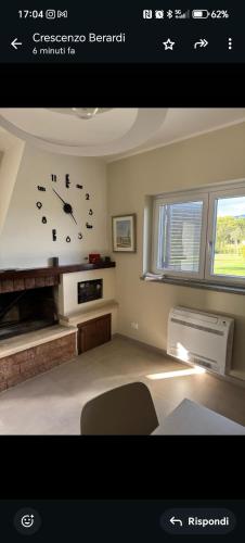 a living room with a clock on the wall at Home Imele in Villa San Sebastiano