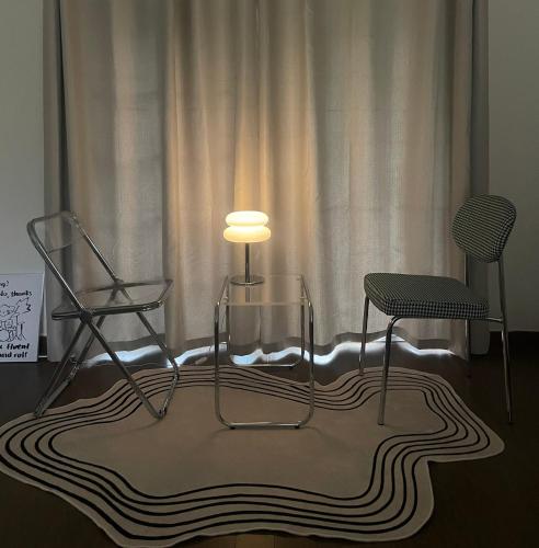 a table and two chairs and a lamp on a rug at Honey Bear Pension in Pyeongchang 