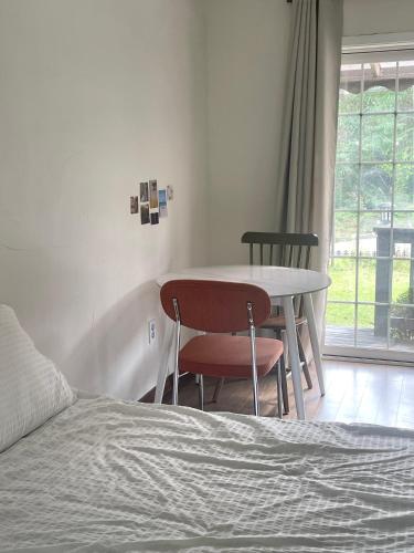 a bedroom with a bed and a table and chairs at Honey Bear Pension in Pyeongchang 