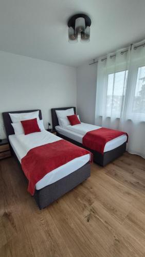 two beds in a room with white and red at Apartments Seibel Doppel-Zweibettzimmer mit Balkon in Reutlingen